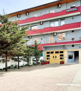 a hotel with a large building with a garage at Hotel Kaloshi in Tirana