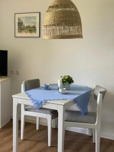 a white table with two chairs with a blue table cloth at Landhaus Tipp in Altenmedingen