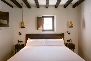 a bedroom with a large white bed with a window at Casa Maca in Ibiza Town