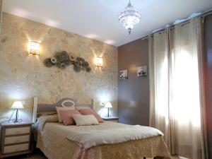 1 dormitorio con 1 cama y una pared con rocas en Magnífico adosado de esquina con vistas al golf playas Islantilla en Islantilla