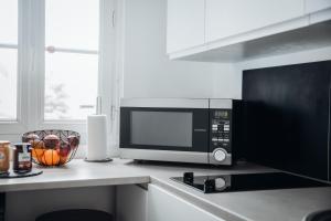 a microwave oven sitting on a counter in a kitchen at appartement neuf, moderne et confortable! in Ernée