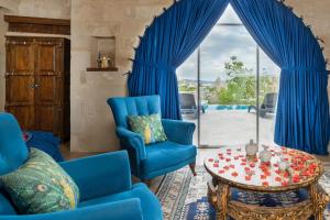Una sala de estar con sillas azules y una mesa. en Doors Of Cappadocia Special Cave Hotel, en Göreme