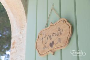 a wooden sign hanging on the side of a house at Masseria Fabula Bistrot & Maison in Monopoli