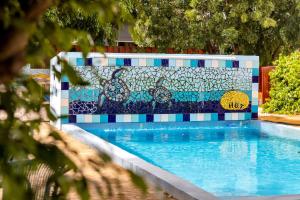 a swimming pool with a mosaic wall next to it at The Hut Bonaire in Kralendijk