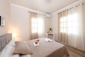 - une chambre avec un lit et un plateau de fleurs dans l'établissement SPYROS APARTMENT, à Diakopto