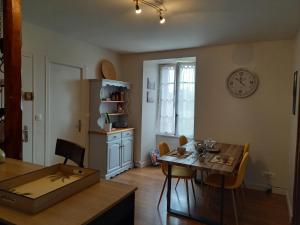 comedor con mesa y reloj en la pared en Kervig House, en Paimpol