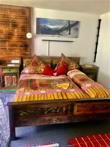 a bedroom with a wooden bed with red pillows at Apartment Gletscherbergblick in Obergurgl