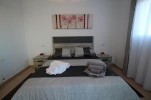1 dormitorio con 1 cama grande y 2 almohadas en Adosado Roldán by Rental Olé, en Roldán