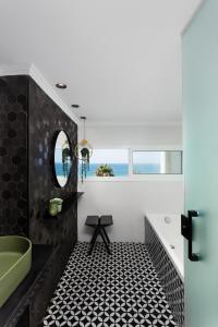 a bathroom with a black and white tile floor at Seaview Stylish Apartment with Balcony in Herzliya