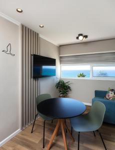 a living room with a table and chairs and a couch at Sea View Stylish 1BR with Balcony by Beachfront Stay in Herzelia 