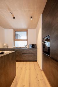 a kitchen with wooden cabinets and a large window at GRIMMINGlofts Top 7 in Bad Mitterndorf