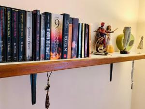 a book shelf with books and toys on it at Vila das Estrelas - Guesthouse in Lençóis
