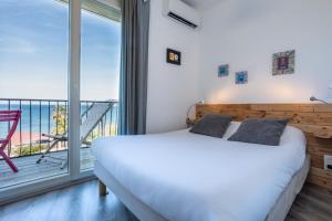 um quarto com uma cama e uma varanda em Hôtel Almanarre Plage - Hôtel Eco-Responsable face à la mer em Hyères