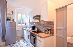 uma cozinha com armários brancos, um lavatório e um frigorífico em Casa Rione em Omessa