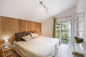 Un dormitorio con una cama grande y una ventana en Mansarda Albero Verde con Piscina en Casanova Lerrore