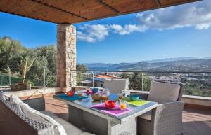 un patio con mesa y sillas en una terraza en Villa Annonciade en LʼÎle-Rousse