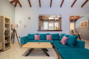 un soggiorno con divano blu e tavolo di Stranis Hill House Zakinthos ad Akrotiri