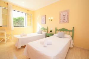 een kamer met twee bedden en een raam bij Villa Miel by Sonne Villas in Cala Galdana +34 foto's