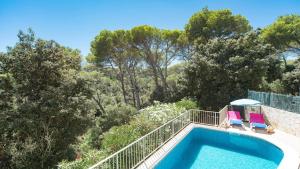 een zwembad met twee ligstoelen naast de avisor bij Villa Miel by Sonne Villas in Cala Galdana