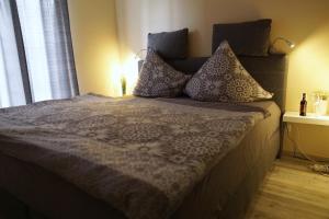 uma cama com almofadas num quarto em Dat Diekhus em Greetsiel