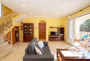 een woonkamer met een bank en een tafel bij Villa Miel by Sonne Villas in Cala Galdana