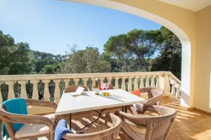 een terras met een tafel en stoelen op een balkon bij Villa Miel by Sonne Villas in Cala Galdana