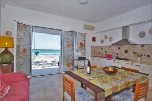 eine Küche und ein Esszimmer mit einem Tisch und Meerblick in der Unterkunft Villa Mirage in Alcamo