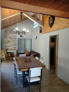 a dining room and living room with a wooden table and chairs at Casa de montaña Manantiales-Nazareth in Potrerillos +72 photos
