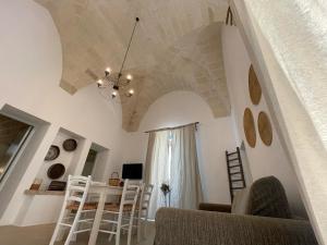 Spongano的住宿－拉科特迪可瑞度假屋，客厅设有白色椅子和天花板