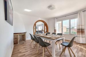 a dining room with a table and chairs and a mirror at Villa Benicolada - PlusHolidays in Calpe