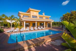 a villa with a swimming pool in front of a house at Villa Bellavista - Plusholidays in Calpe