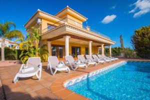 a villa with a swimming pool and lounge chairs at Villa Bellavista - Plusholidays in Calpe