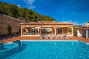 a house with a swimming pool and a villa at Villa Noa - PlusHolidays in Calpe
