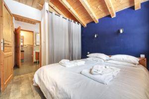 a bedroom with a large white bed with towels on it at Chalet Minouche in Chamonix-Mont-Blanc