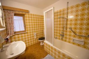 een badkamer met een toilet, een douche en een wastafel bij Apartment Soval in Ortisei
