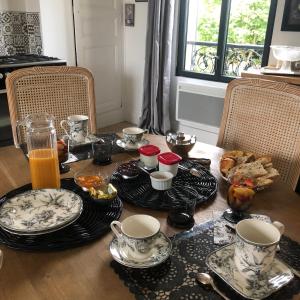 ein Tisch mit Tassen und Teller mit Essen drauf in der Unterkunft Le Clos Montrichard in Montrichard