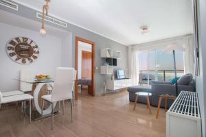 a living room with a table and a dining room at Apartamento Barlovento - PlusHolidays in Calpe