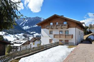 uma casa nas montanhas com neve no chão em Apartment Rainer em Ortisei