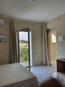 a bedroom with a bed and a sliding glass door at B&B La Leggenda in Vieste