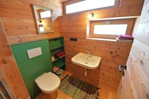 a small bathroom with a toilet and a sink at Design Lodge The Cube in Ortisei