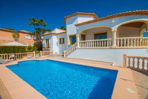 a villa with a swimming pool in front of a house at Villa Altamira - Plusholidays in Calpe