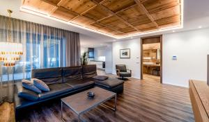 a living room with a leather couch and a table at Apartments Rumanon in Ortisei