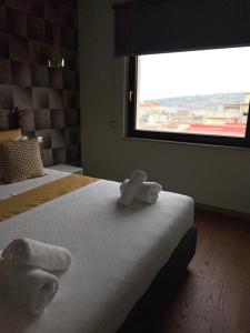 ナポリにあるLa Casa Di Ericaのベッドルーム1室(窓のあるベッド1台にタオル2枚付)