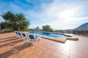 a group of chairs sitting next to a swimming pool at Villa Bou - PlusHolidays in Calpe