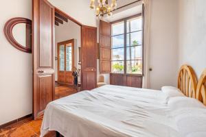 1 dormitorio con cama blanca y ventana en Sa Torre - Felanitx, en Felanitx