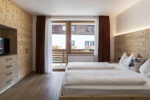 een grote slaapkamer met 2 bedden en een raam bij Apartments Jalve in Ortisei