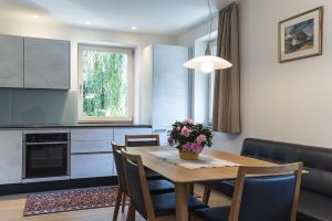 una cocina con mesa de comedor y un jarrón de flores en Apartments Jalve, en Ortisei
