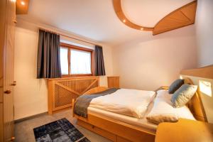 um pequeno quarto com uma cama e uma janela em Apartment Sellablick em Ortisei