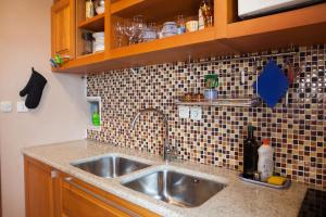 eine Küche mit einem Waschbecken und einer gefliesten Wand in der Unterkunft Studio Zavala in Zavala