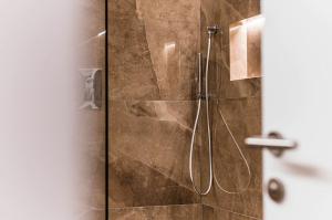 a bathroom with a shower with a glass door at Apartments Rumanon in Ortisei